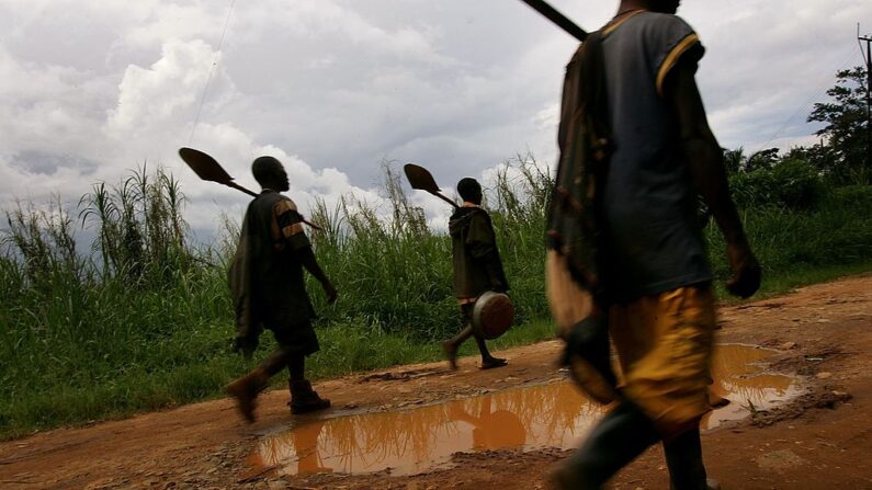 Mineros caminan hacia su casa por un camino de tierra el 29 de marzo de 2006 en la ciudad minera de oro de Mongbwalu, Congo. (Spencer Platt/Getty Images)