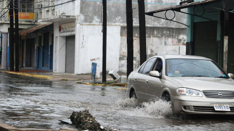 Un coche circula por una calle inundada por el huracán Dean el 20 de agosto de 2007 en Kingston, Jamaica. (Anthony A Foster/AFP vía Getty Images)
