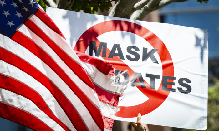 Un manifestante sostiene un cartel en contra de los mandatos de mascarillas, en Costa Mesa, California, el 10 de junio de 2021. (John Fredricks/The Epoch Times)
