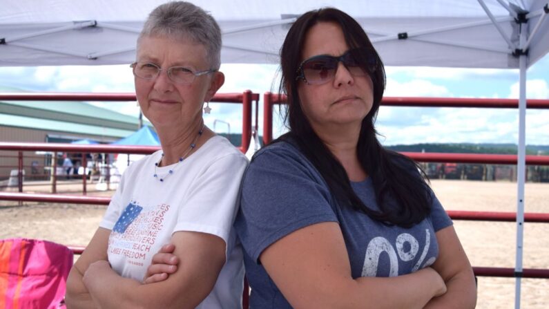 Tras ser procesadas por negarse a llevar mascarillas en una reunión del consejo escolar local, Elaine Barnhart (izq.) y Katherine Detwiler recogieron donaciones para ayudar a pagar sus gastos legales en una reunión política patriótica en el condado de Columbia, Pensilvania, el 27 de agosto de 2022. (Beth Brelje/The Epoch Times)
