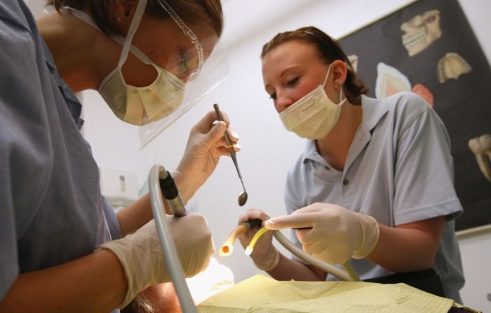 Una dentista y su asistente se preparan para limpiar los dientes de un paciente en esta ilustración fotográfica en la oficina de un dentista el 12 de octubre de 2009 en Berlín, Alemania. (Sean Gallup/Getty Images)