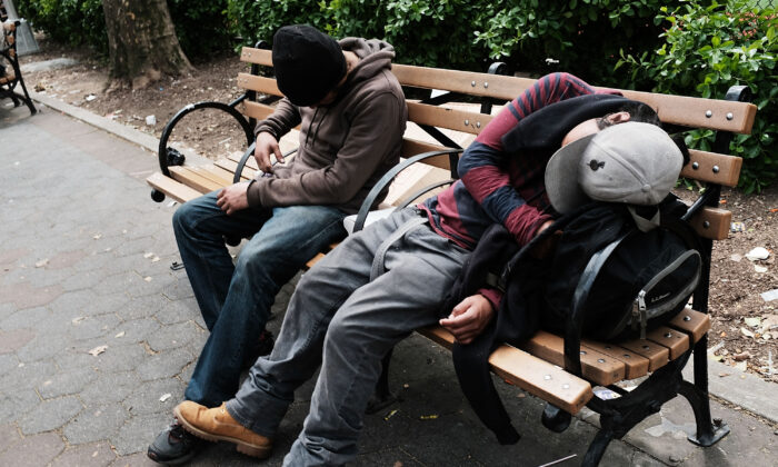 Un par de hombres sentados el 4 de mayo de 2018 en un parque en el Bronx, Nueva York, parecen desmayados en un lugar donde los consumidores de heroína se reúnen para inyectarse. (Spencer Platt/Getty Images)