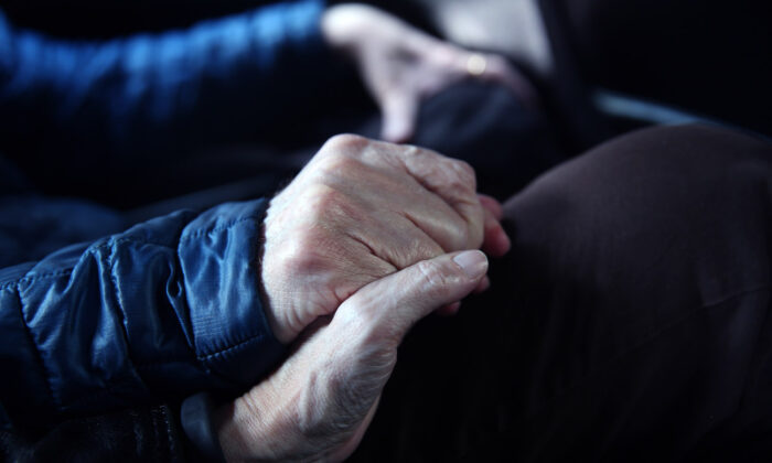 Un paciente con cáncer cogido de la mano de su mujer en Nueva York, el 16 de marzo de 2016. (John Moore/Getty Images)
