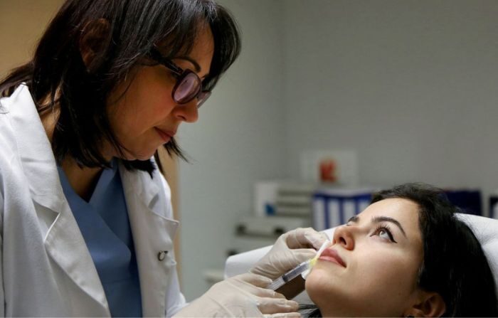 La dermatóloga Monika Fida (I) pone a una mujer una inyección de ácido hialurónico para aumentar los labios en su clínica el 10 de enero de 2017. Imagen ilustrativa. GENT SHKULLAKU/AFP vía Getty Images)