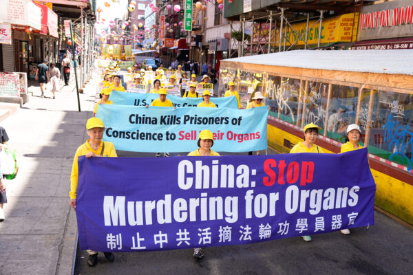 Practicantes de Falun Gong en un desfile que denuncia los 23 años de percusión del PCCh a sus creencias en China, el 10 de julio de 2022, en el barrio chino de Nueva York. (Larry Dye/The Epoch Times)