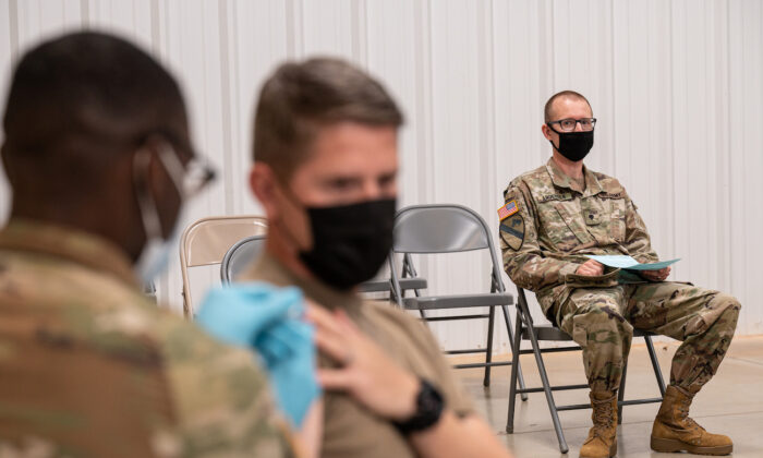 Un soldado observa a otro soldado cuando recibe la vacuna contra el COVID-19 en los Servicios Médicos Preventivos del Ejército, en Fort Knox, Ky., el 9 de septiembre de 2021. (Jon Cherry/Getty Images)