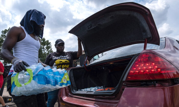 Residentes distribuyen cajas de agua en el Centro Comunitario Grove Park en Jackson, Mississippi, el 3 de septiembre de 2022. (Seth Herald/AFP vía Getty Images)