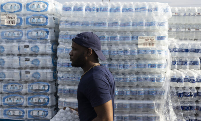 Un empleado de la ciudad de Jackson ayuda a repartir cajas de agua embotellada en un lugar de distribución de la Coalición de Respuesta Rápida de Mississippi en Jackson, Mississippi, el 31 de agosto de 2022. (Brad Vest/Getty Images)