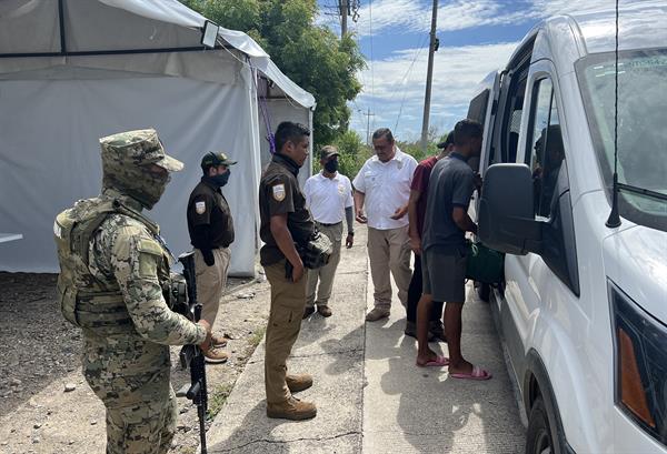 Personal del Instituto Nacional de Migración (INM), auxilian a un grupo de migrantes que caminan por la carretera hacia el municipio de San Pedro Tapanatepec, en el estado de Oaxaca (México), el 23 de octubre de 2022. EFE/Jesús Méndez
