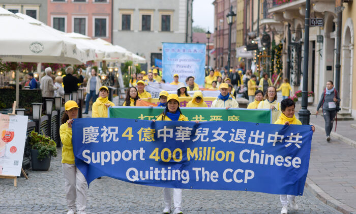 Los practicantes de Falun Dafa llevan una pancarta que celebra las 400 millones de renuncias al PCCh como parte del Movimiento Tuidang en China, durante una marcha por el centro de Varsovia, Polonia, el 9 de septiembre de 2022. (Mihut Savu/The Epoch Times)