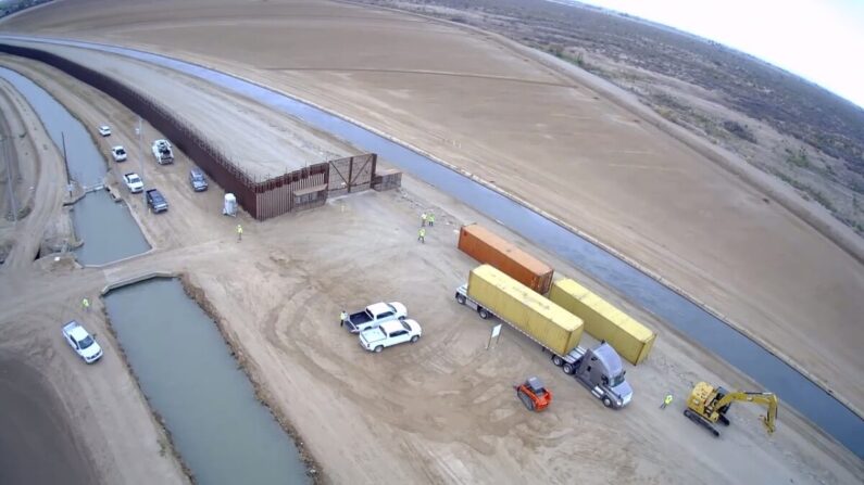 Contratistas comienzan a apilar contenedores de transporte en los huecos de la valla fronteriza cerca de Yuma, Arizona, el 12 de agosto de 2022. (Cortesía de la oficina del gobernador de Arizona)
