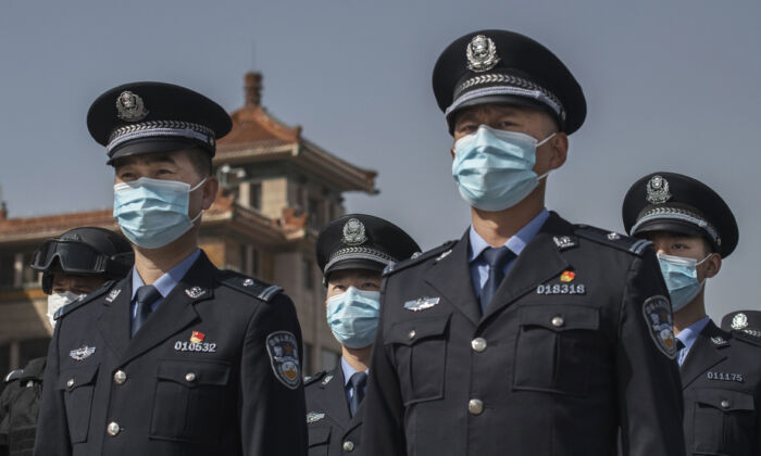 Oficiales de policía chinos usan mascarillas en la estación de tren de Beijing, el 4 de abril de 2020. (Kevin Frayer/Getty Images)
