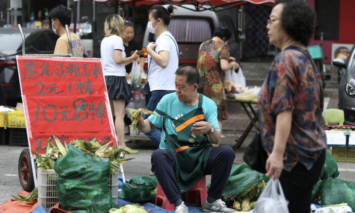 Un vendedor de maíz espera a los clientes en un mercado de Shenyang, en la provincia nororiental china de Liaoning, el 9 de julio de 2022. (STR/AFP a través de Getty Images)