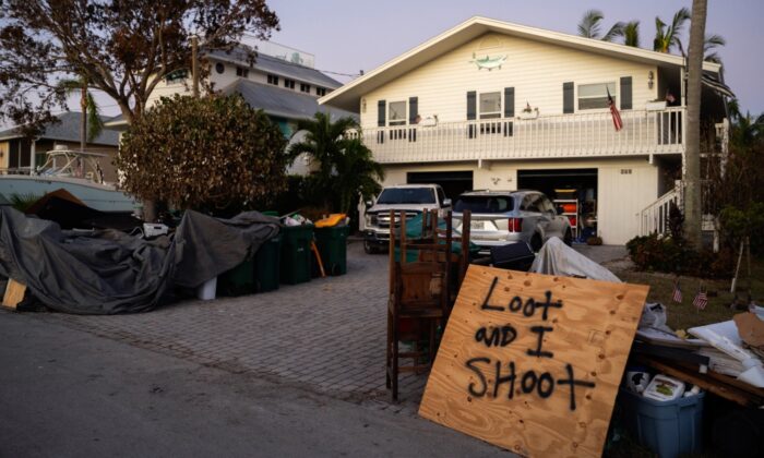 Un letrero que dice "[usted] saquea y yo disparo" se encuentra afuera de una casa dañada por la tormenta tras el paso del huracán Ian, en Naples, Florida, el 2 de octubre de 2022. (Sean Rayford/Getty Images)
