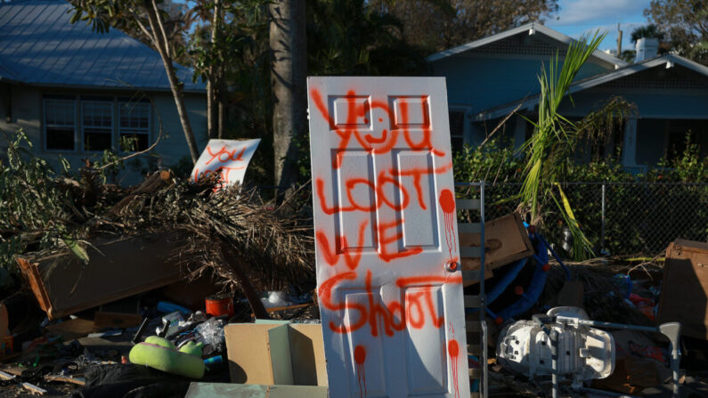 En una puerta pintada con spray se lee 'tú saqueas, nosotros disparamos' en Fort Myers, Florida, el 7 de octubre de 2022. (Joe Raedle/Getty Images)
