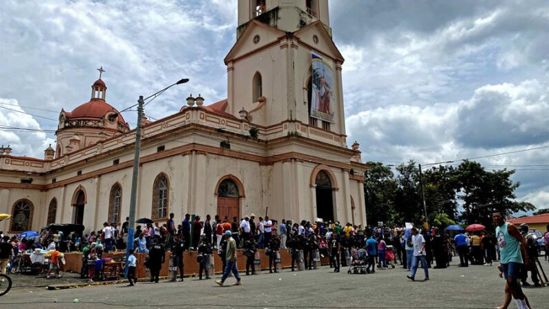 Fotografía de archivo, tomada el pasado 30 de septiembre, en la que se registró a varios agentes antidisturbios de la policía nacional de Nicaragua al vigilar la entrada principal de la iglesia de San Jerónimo, durante una misa en su honor, en Masaya (Nicaragua). EFE/Stringer
