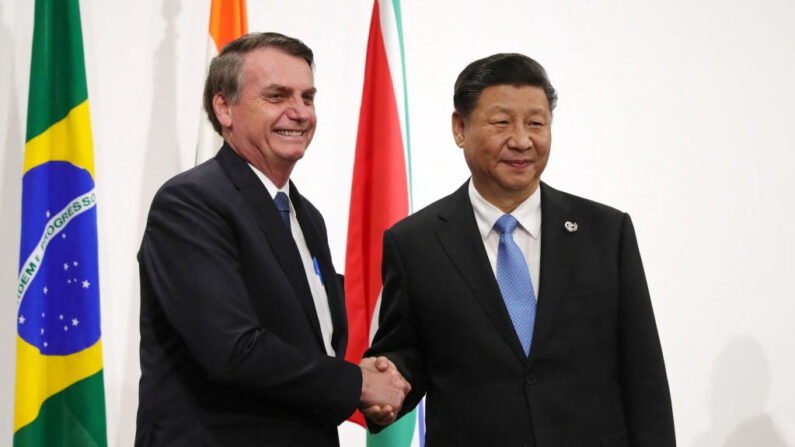 El presidente de Brasil, Jair Bolsonaro (i), estrecha la mano del líder de China, Xi Jinping, durante una reunión de la cumbre de los BRICS en la cumbre del G-20 en Osaka (Japón), el 28 de junio de 2019. (Mikhail Klimentyev/AFP vía Getty Images)