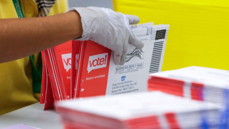 Un trabajador electoral abre los sobres que contienen las papeletas de voto por correo para las primarias del estado de Washington del 4 de agosto en King County Elections en Renton, Washington, el 3 de agosto de 2020. (Jason Redmond/AFP vía Getty Images)
