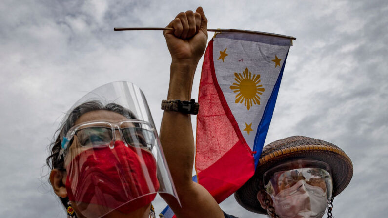 Los filipinos son vistos usando mascarillas y protectores faciales para protegerse de COVID-19 mientras marcan el día de la Independencia con una protesta contra las continuas intrusiones chinas en aguas filipinas, frente a la Embajada de China el 12 de junio de 2021 en Makati, Metro Manila, Filipinas. (Ezra Acayan/Getty Images)
