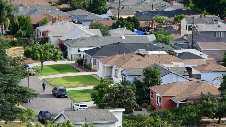 Un hombre camina por una calle en un barrio de casas unifamiliares en Los Ángeles el 30 de julio de 2021. (Frederic J. Brown/AFP vía Getty Images)