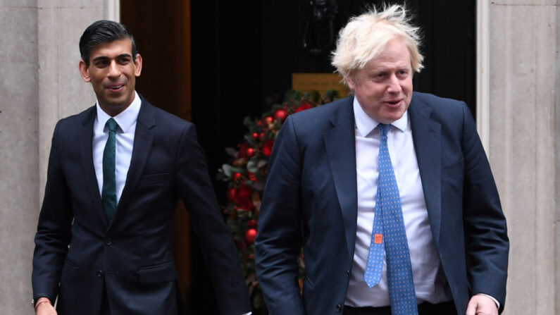 El ex primer ministro británico, Boris Johnson (d), y el exministro de Hacienda, Rishi Sunak, llegan para ver una flota de vehículos eléctricos antes del Small Business Saturday en Downing Street, en el centro de Londres, el 1 de diciembre de 2021. (Daniel Leal/AFP vía Getty Images)