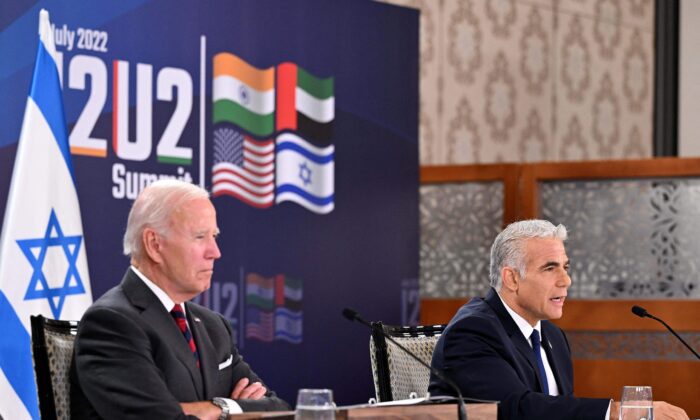 El presidente de EE.UU., Joe Biden (izq.), y el primer ministro de Israel, Yair Lapid, participan en una reunión virtual con los líderes del grupo I2U2, que incluye a EE.UU., Israel, India y los Emiratos Árabes Unidos, en un hotel en Jerusalén, el 14 de julio de 2022. (MANDEL NGAN/AFP vía Getty Images)
