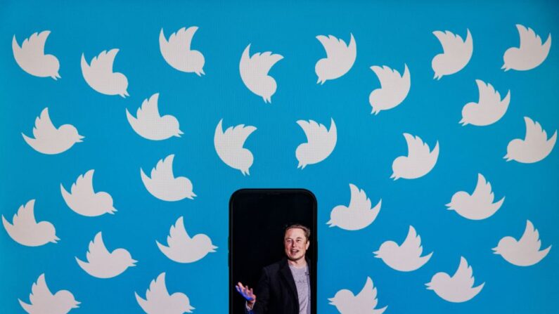 Un teléfono celular, con una foto de Elon Musk, ante un monitor de computadora lleno de logotipos de Twitter, en Washington, D.C., el 5 de agosto de 2022. (Samuel Corum/AFP vía Getty Images)