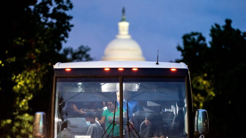 Inmigrantes ilegales, que subieron a un autobús en Texas, son dejados a la vista del edificio del Capitolio de Estados Unidos en Washington, DC el 11 de agosto de 2022. (Stefani Reynolds/AFP vía Getty Images)
