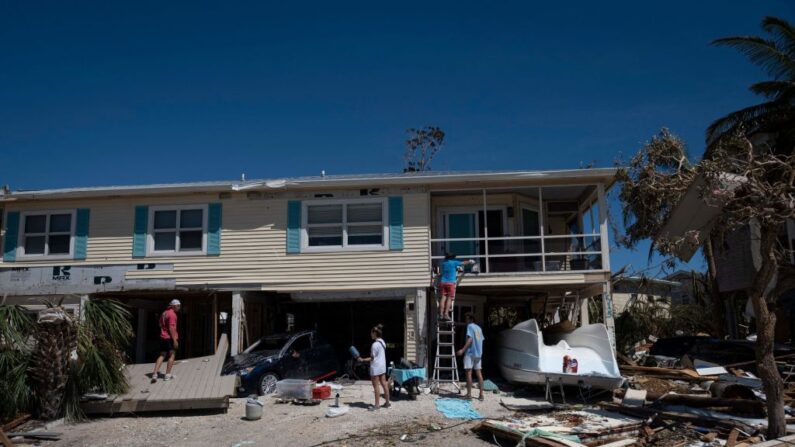 Unas personas buscan sus pertenencias en su casa dañada tras el paso del huracán Ian en Fort Myers, Florida, el 30 de septiembre de 2022. (Ricardo Arduengo/AFP vía Getty Images)