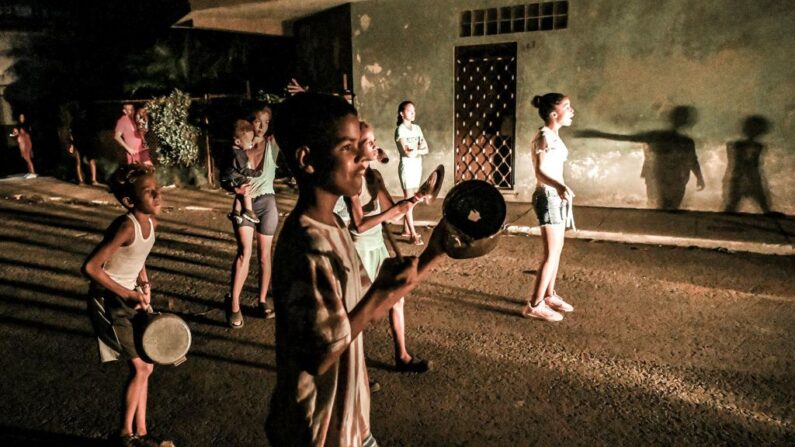 Unos jóvenes tocan tambores en señal de protesta en medio de un prolongado apagón eléctrico tras el paso del huracán Ian por La Habana (Cuba) el 30 de septiembre de 2022. (Yamil Lage/AFP vía Getty Images)