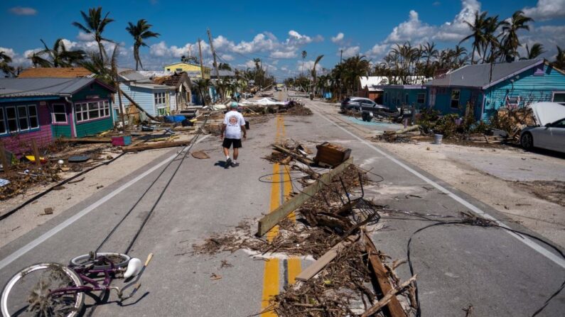 Un hombre pasa junto a los escombros esparcidos en Pine Island Road tras el paso del huracán Ian por Matlacha, Florida, el 1 de octubre de 2022. (Ricardo Arduengo/AFP vía Getty Images)