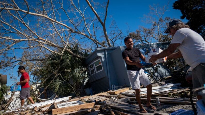 José Ramírez recibe comida y suministros de un vecino tras el paso del huracán Ian en Fort Myers Beach, Florida, el 2 de octubre de 2022. (Ricardo Arduengo/AFP vía Getty Images)