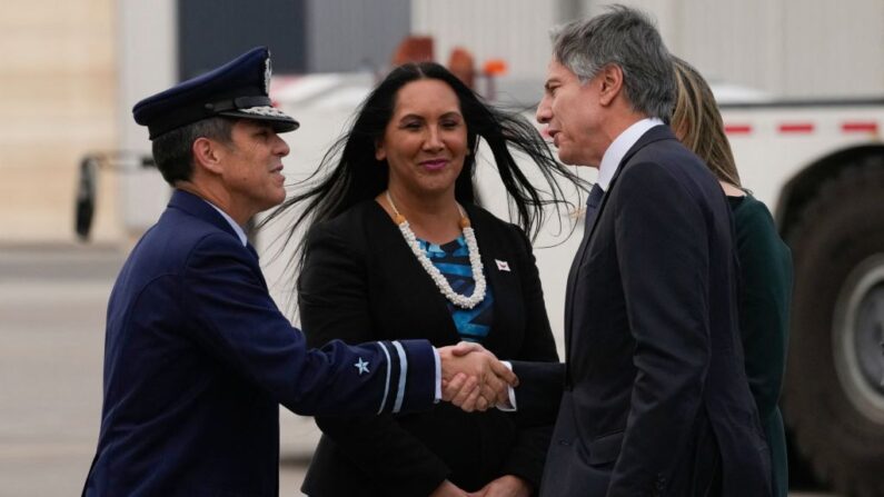 El secretario de Estado de EE.UU., Antony Blinken, saluda a un funcionario no identificado junto al Director de Ceremonial y Protocolo de Chile, Manahi Pakarati (c), a su llegada a Santiago de Chile, el 4 de octubre de 2022. (Esteban Felix/POOL/AFP vía Getty Images)