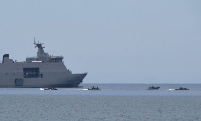 Los vehículos de asalto anfibio de los marines filipinos maniobran junto a un buque de la marina filipina BRP Tarlac con plataforma de desembarco durante un ejercicio de desembarco anfibio conjunto con los marines estadounidenses en una playa frente al Mar de China Meridional, en la ciudad de San Antonio, provincia de Zambales, el 7 de octubre de 2022. (Ted Aljibe/AFP vía Getty Images)