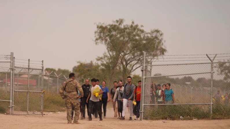 Un oficial de la Guardia Nacional de Texas conduce a un grupo de migrantes para ser procesados por la Patrulla Fronteriza de Estados Unidos después de cruzar ilegalmente la frontera sur de Estados Unidos con México el 9 de octubre de 2022 en Eagle Pass, Texas.(ALLISON DINNER/AFP via Getty Images)