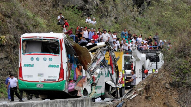 Rescatistas aseguran un autobús para que no caiga por un barranco tras un accidente en la carretera Panamericana en Altos de Peñalisa, cerca de la ciudad de Pasto, en el departamento colombiano de Nariño, el 15 de octubre de 2022. (Leonardo Castro/AFP vía Getty Images)