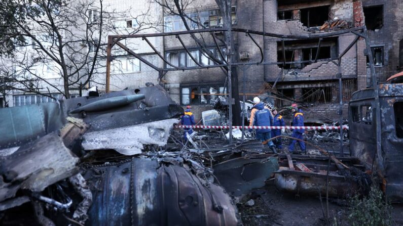 Personal de Emergencias de Rusia retira los restos de un avión militar Sukhoi Su-34 del lugar donde se estrelló, en el patio de una zona residencial en la ciudad de Yeysk, en el suroeste de Rusia, el 18 de octubre de 2022. (STRINGER/AFP vía Getty Images)