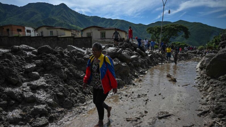 Una mujer camina en El Castaño, un barrio de Maracay, la capital del norteño estado de Aragua (Venezuela), el 18 de octubre de 2022, un día después de que las intensas lluvias provocaran inundaciones y un deslizamiento de tierra. (Federico Parra/AFP vía Getty Images)