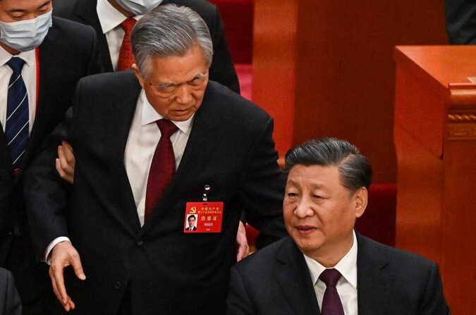 El líder chino Xi Jinping (D) habla con el exlíder Hu Jintao mientras es asistido para salir de la ceremonia de clausura de la conferencia política del Partido Comunista Chino en el Gran Salón del Pueblo en Beijing el 22 de octubre de 2022. (Noel Celis/AFP vía Getty Images)
