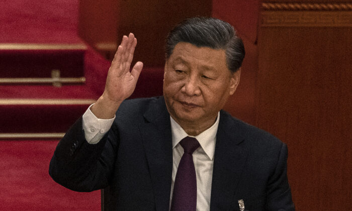 El líder chino Xi Jinping levanta la mano mientras vota durante la sesión de clausura del 20º Congreso Nacional del Partido Comunista Chino en el Gran Salón del Pueblo en Beijing, el 22 de octubre de 2022. (Kevin Frayer/Getty Images)