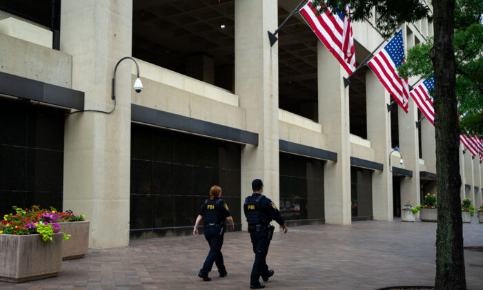 Agentes de la ley pasan frente al edificio J. Edgar Hoover del FBI, en Washington, el 21 de julio de 2022. (Chung I Ho/The Epoch Times)

