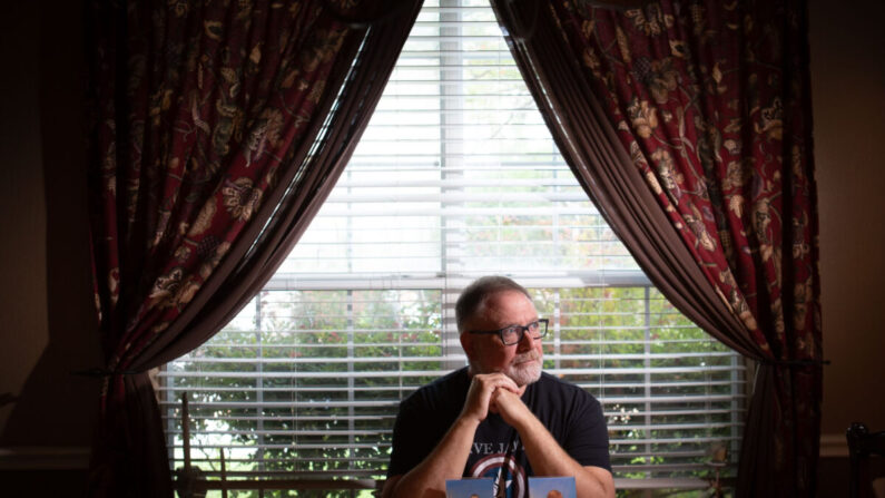 Jeff Younger se sienta solo detrás de las fotos de sus hijos gemelos en su casa del norte de Texas el 16 de septiembre de 2022. (Bobby Sanchez para The Epoch Times)
