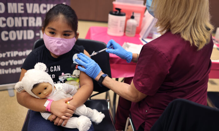 La estudiante de primer grado, Rihanna Chihuaque, de siete años, recibe una vacuna contra el covid-19, en el Instituto Arturo Velasquez, el 12 de noviembre de 2021, en Chicago, Illinois. (Scott Olson/Getty Images)
