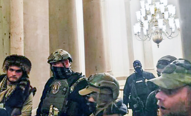 Los Oath Keepers se enfrentan a una multitud enfurecida frente al oficial de la Policía del Capitolio de Estados Unidos, Harry Dunn, poco antes de las 3 de la tarde del 6 de enero de 2021. (Kelly Meggs/Screenshot via The Epoch Times)
