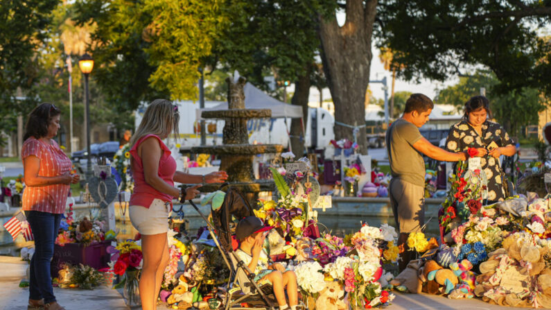 La gente visita un monumento improvisado para los 19 niños y dos profesores muertos en el tiroteo masivo del 24 de mayo se encuentra en la plaza del pueblo en Uvalde, Texas, el 21 de junio de 2022. (Charlotte Cuthbertson/The Epoch Times)
