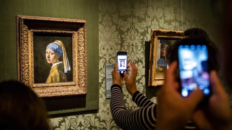 Visitantes toman fotografías de 'La joven de la Perla', del artista holandés Johannes Vermeer, en el Museo Mauritshuis de La Haya, en Países Bajos, este 27 de octubre de 2022. EFE/EPA/Bart Maat