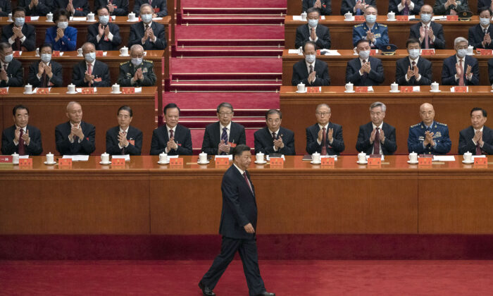 El líder chino, Xi Jinping, es aplaudido por altos miembros del Partido Comunista Chino mientras camina hacia el podio antes de su discurso durante la ceremonia de apertura del 20º Congreso Nacional del Partido, en el Gran Salón del Pueblo, en Beijing, el 16 de octubre de 2022. (Kevin Frayer/Getty Images)

