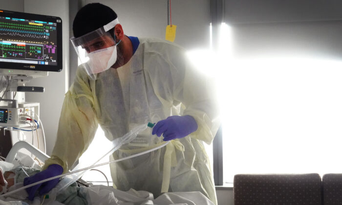 Un terapeuta respiratorio atiende a un paciente con COVID-19 en el Centro Médico de la Universidad Rush en Chicago, Illinois, el 31 de enero de 2022. (Scott Olson/Getty Images)