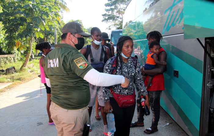 Imagen de archivo de inmigrantes centroamericanos y haitianos haciendo fila para abordar autobuses. EFE/Juan Manuel Blanco