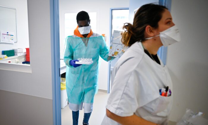 Personal médico de un laboratorio analiza muestras sobre la posible presencia de COVID-19, en una foto de archivo. (Gerard Julien/AFP vía Getty Images)
